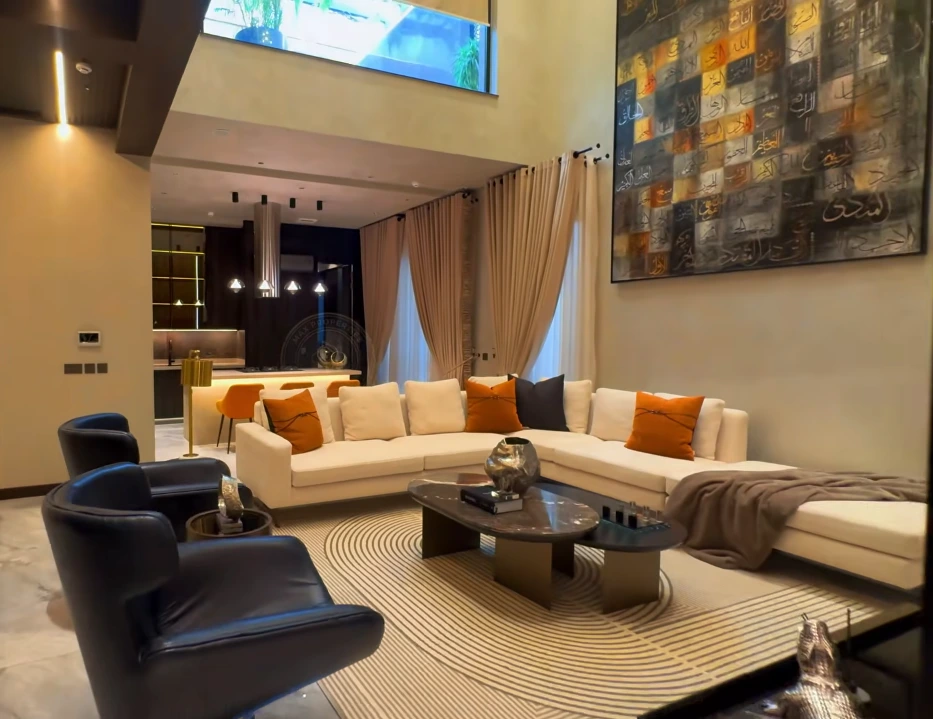 Elegant modern living room with beige furniture, wooden textures, and warm interior lighting.